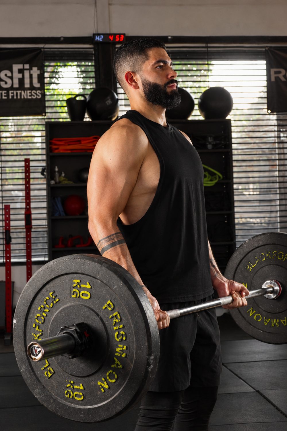 César Vargas haciendo curl con barra en el gimnasio